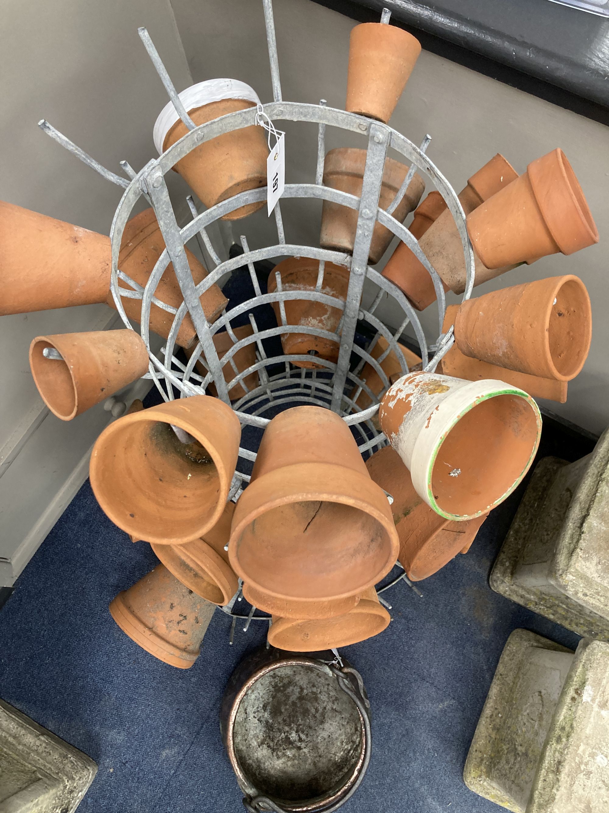 A French metal terracotta pot holder, height 102cm with assorted terracotta pots and an Eastern copper pan, height 21cm